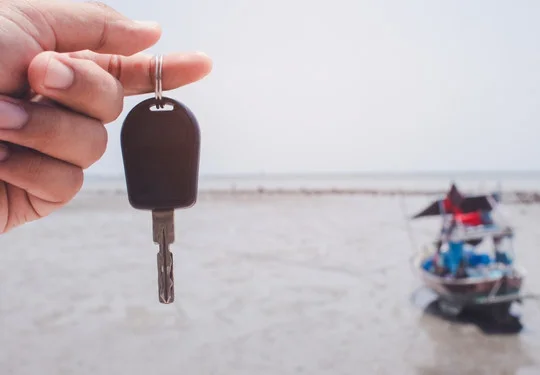 A hand holds a key for a boat