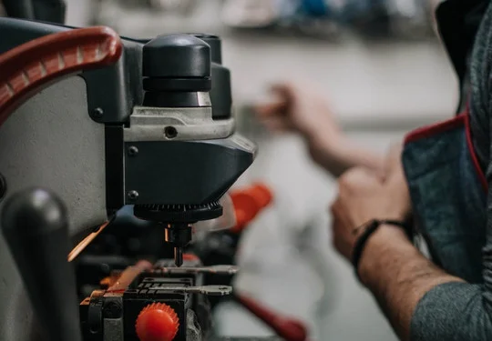 A tech operates a key duplication machine