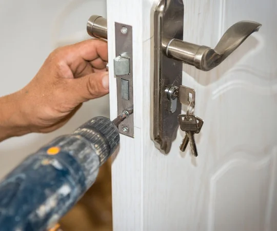 A technician changes a deadbolt faceplate