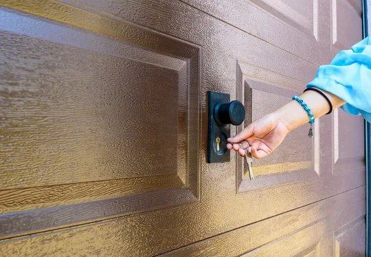 A person inserts a key into a garage door lock