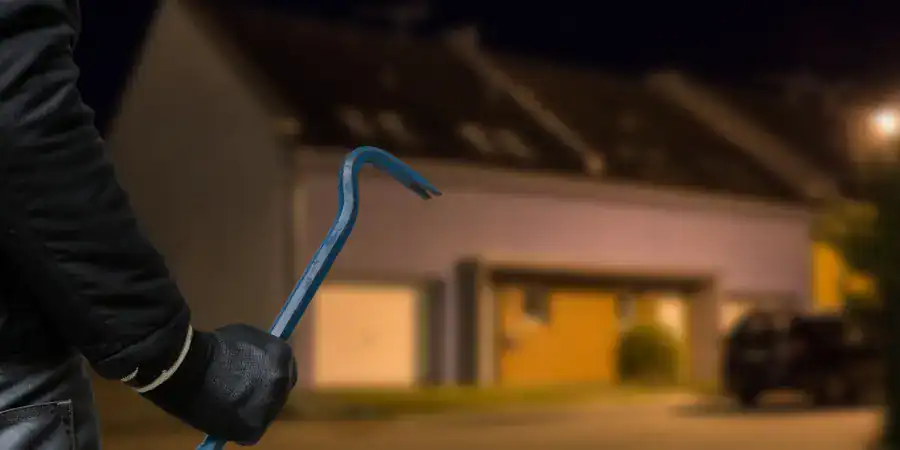 A burglar approaches a home at night