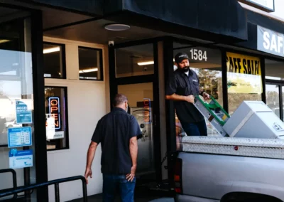 A worker loads a safe onto a truck