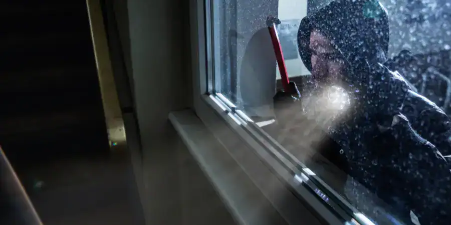 A burglar peers into a home