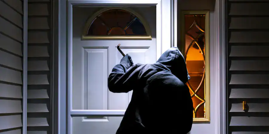 An intruder attempts to pry open a door